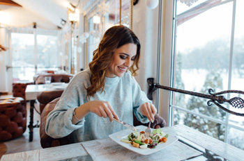 Woman smiling while eating at restaurant